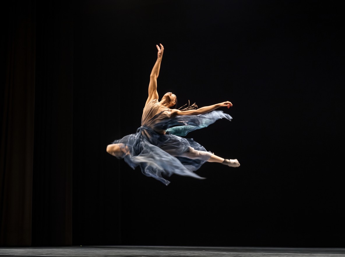 Bailarina suspendida en un salto sobre el escenario